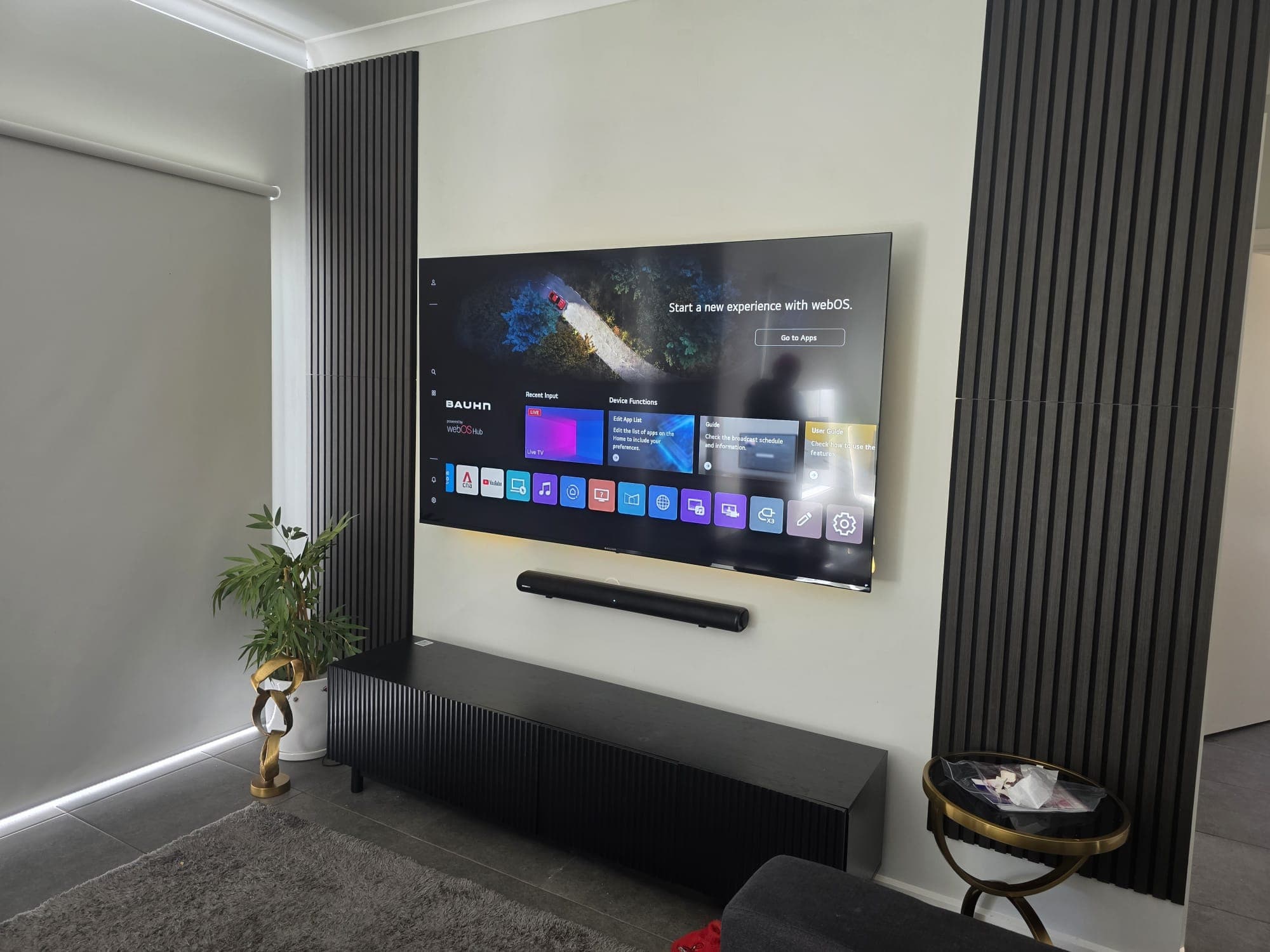 Custom marble and oak entertainment wall with a mounted TV from a Clear View job