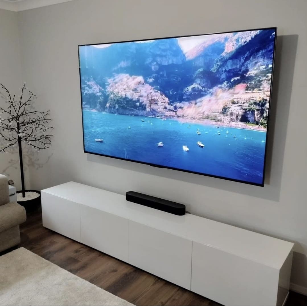 Square TV display with coastal scene and soundbar